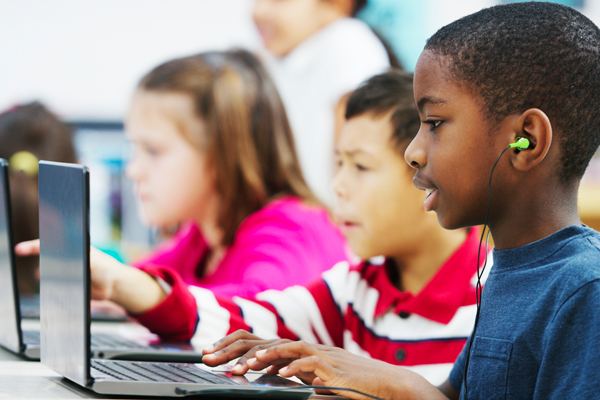Children using laptops in classroom